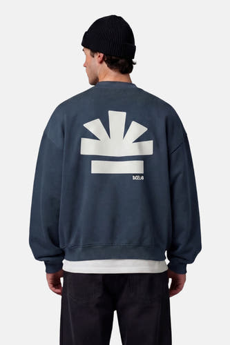 Pull bleu de BASELAB, avec un grand logo graphique blanc dans le dos.