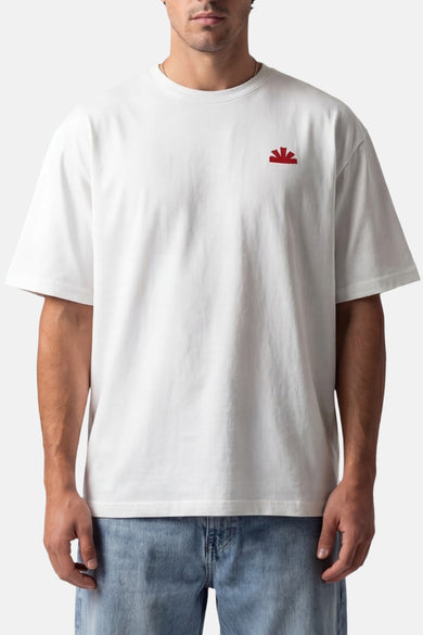 T-shirt blanc à manches courtes de BASELAB, avec un petit logo rouge sur la poitrine et porté avec un jean.