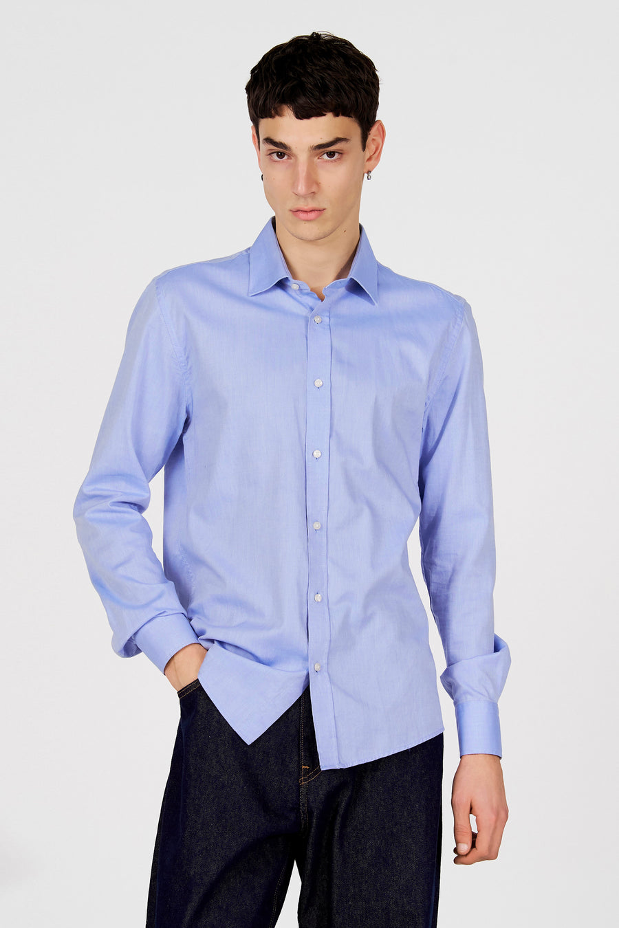 Blauw overhemd met lange mouwen van Le Fabuleux Marcel de Bruxelles, met knoopsluiting, gedragen met een donkere jeans.

