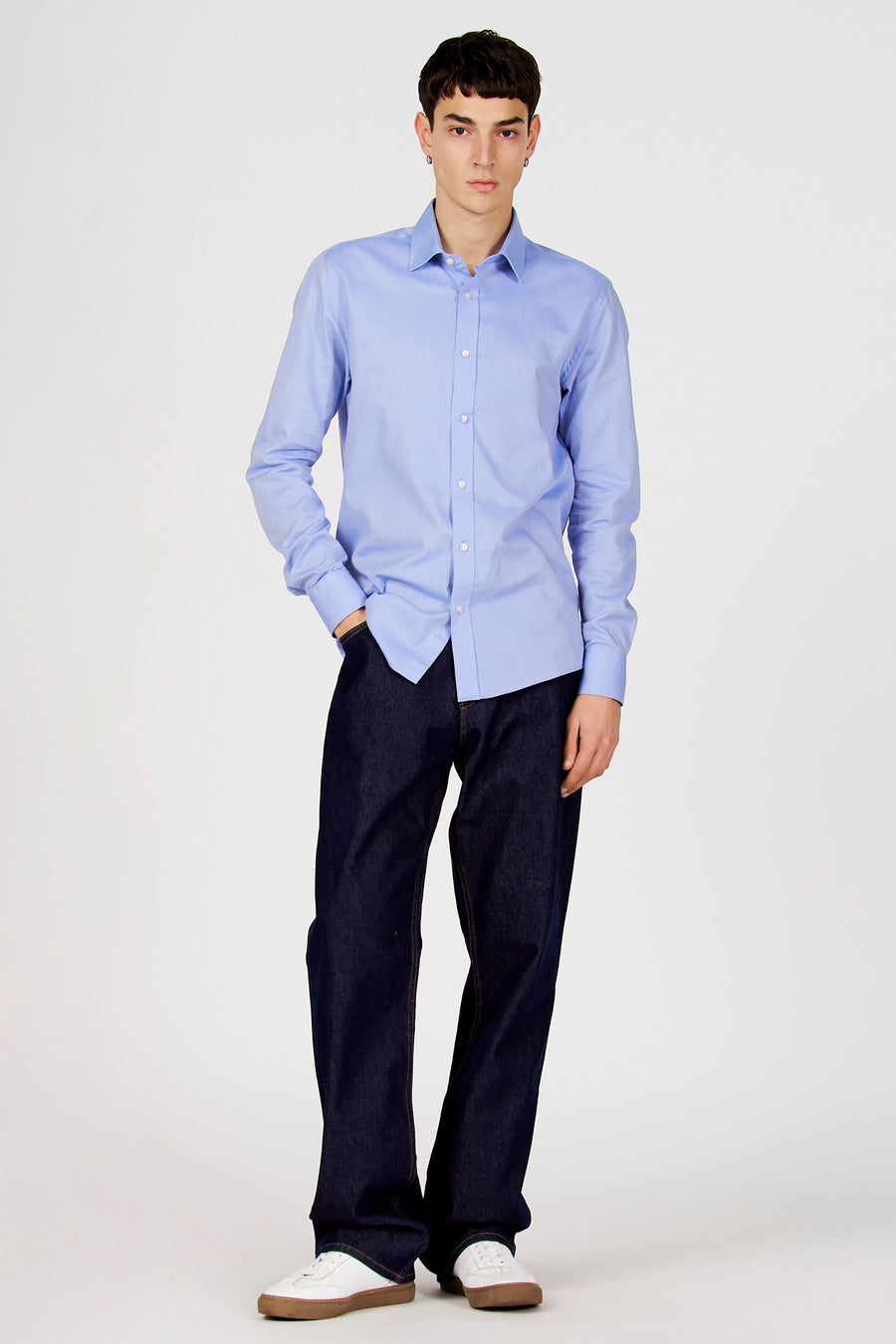 Blauw overhemd met lange mouwen van Le Fabuleux Marcel de Bruxelles, gedragen met donkere jeans en witte sneakers.
