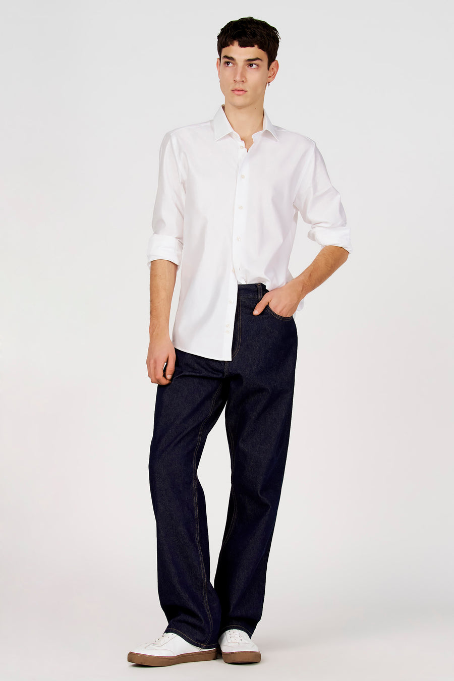 Wit overhemd met lange mouwen van Le Fabuleux Marcel de Bruxelles, gedragen met donkerblauwe jeans en witte sneakers.