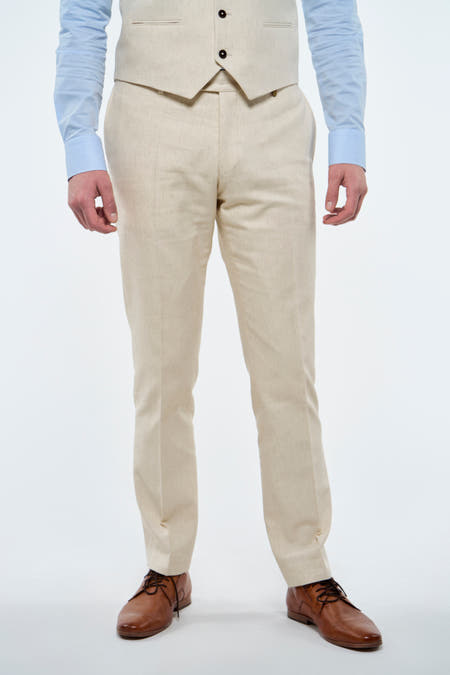 Pantalon beige Le Fabuleux Marcel de Bruxelles, avec des chaussures marrons et une chemise bleu clair.