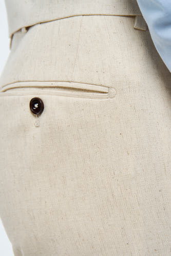 Beige kostuumbroek van Le Fabuleux Marcel de Bruxelles, met een textuurpatroon en een knoop op de achterzak.