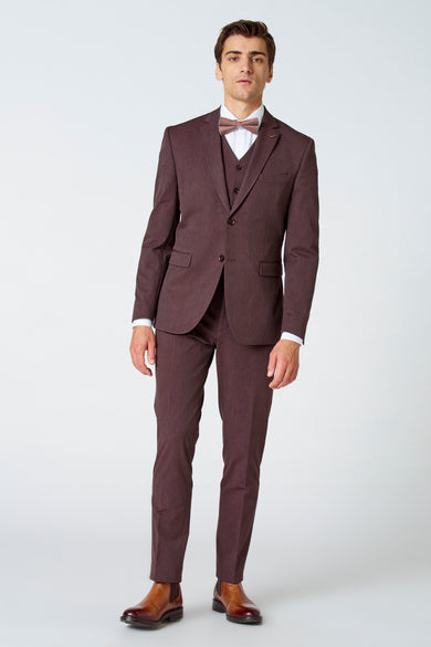 Bruine blazer van Le Fabuleux Marcel de Bruxelles, gedragen met een geruit strikje, wit overhemd en bruine schoenen.
