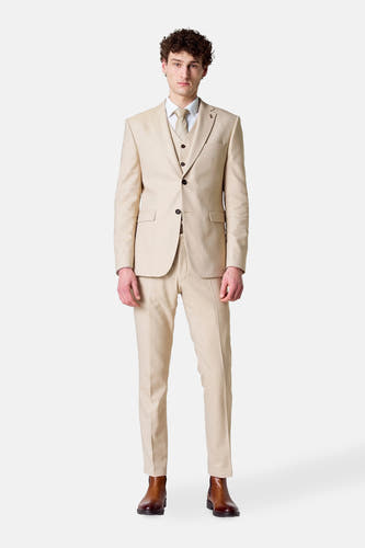 Blazer beige de Le Fabuleux Marcel de Bruxelles, porté avec un gilet, une chemise blanche, une cravate et des chaussures marrons.