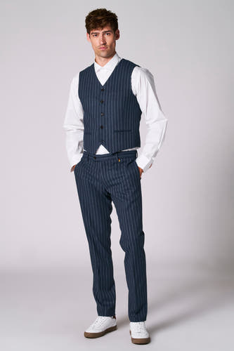 Blauw gilet van Le Fabuleux Marcel de Bruxelles, gedragen met een wit overhemd en een bijpassende gestreepte broek.

