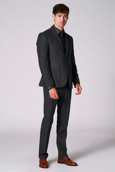 Bruine blazer van Le Fabuleux Marcel de Bruxelles, gedragen met een donker shirt en een bijpassende pantalon, met bruine schoenen.
