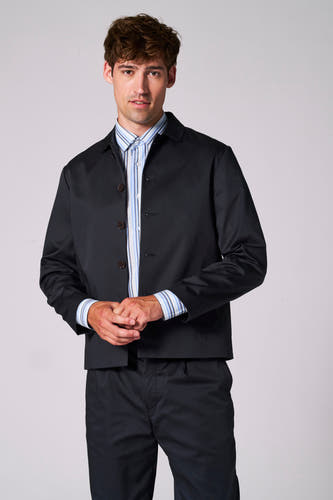 Blauwe blazer van Le Fabuleux Marcel de Bruxelles, gedragen over een gestreept overhemd, met bijpassende broek.
