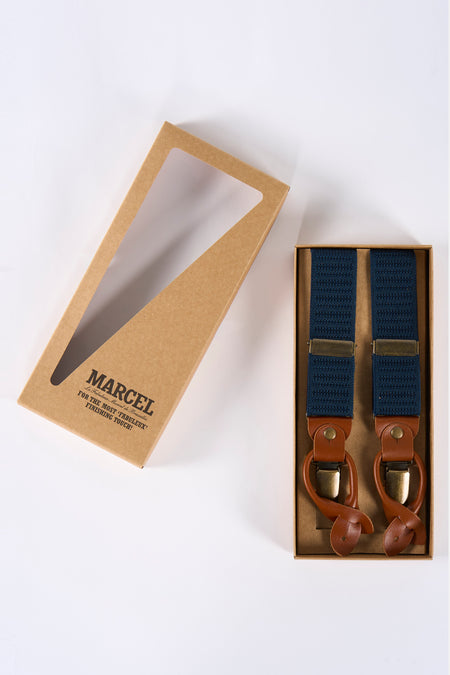 Open bruine doos met donkerblauwe bretels met leren details.