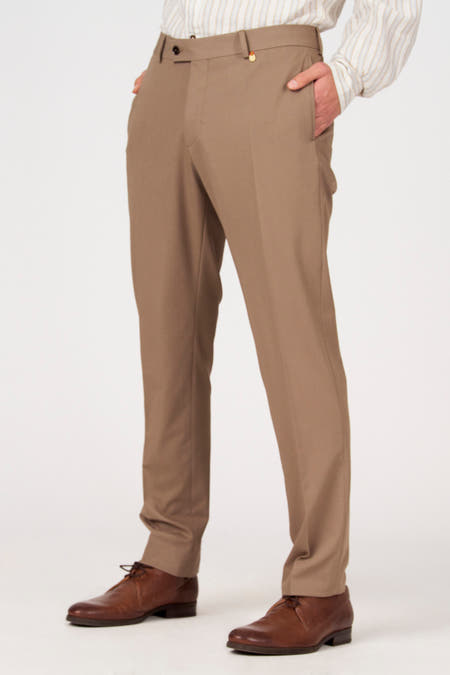 Pantalon de costume marron de Le Fabuleux Marcel de Bruxelles, vu de dos, avec poches et passants de ceinture, combiné avec une chemise rayée.