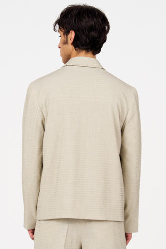 Beige blazer van Le Fabuleux Marcel de Bruxelles, gezien van achteren, met een fijn verticaal streepjespatroon.