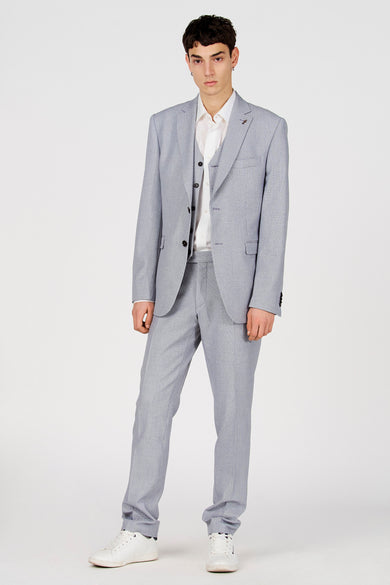 Blauwe blazer van Le Fabuleux Marcel de Bruxelles, met een vest, overhemd en witte sneakers.
