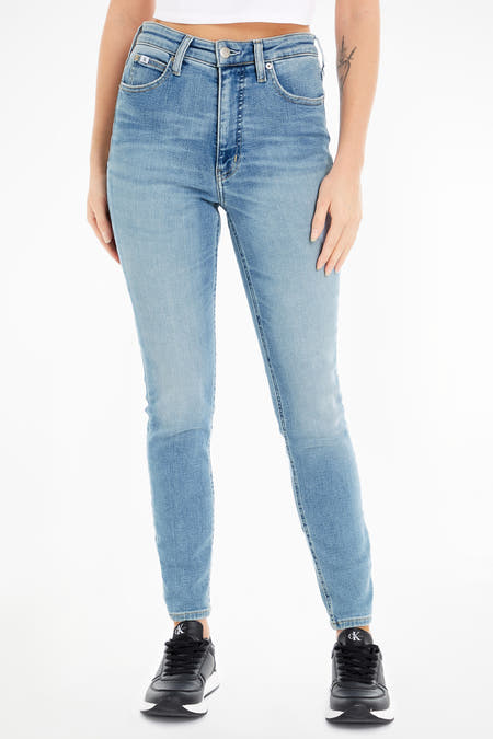 Lichtblauwe skinny jeans van Calvin Klein, met een hoge taille en gecombineerd met zwarte sneakers.
