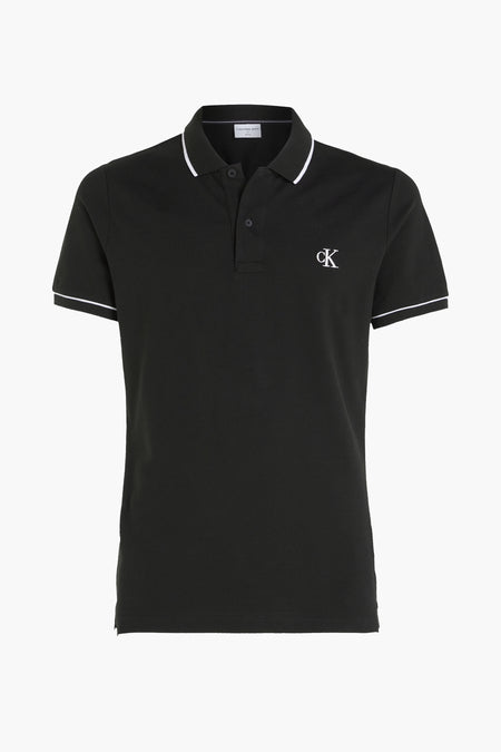 Zwarte polo van Calvin Klein met een witte rand aan de kraag en mouwen, en een CK-logo op de borst.

