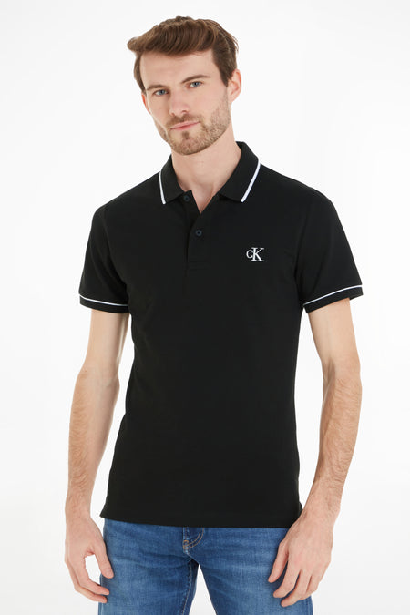 Zwart poloshirt van Calvin Klein, met korte mouwen en witte bies langs de kraag en mouwen.