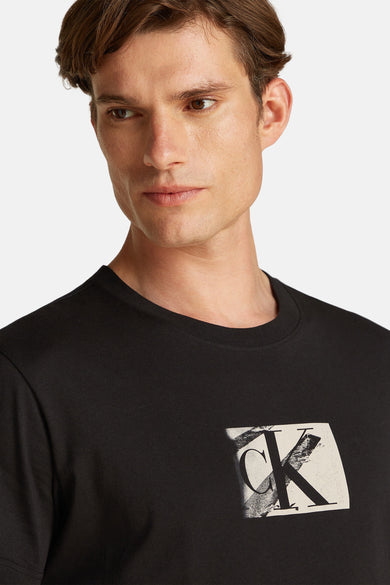 T-shirt noir à manches courtes de Calvin Klein, avec impression de logo sur la partie avant.