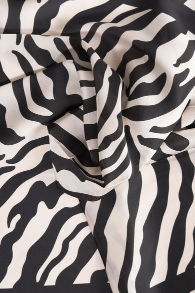 Châle noir Access® avec un motif imprimé zèbre frappant et une texture de tissu pliée.