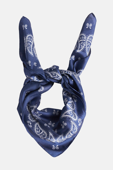 Blauwe zomersjaal van Access® met wit paisley motief, geknoopt in een decoratieve knoop.
