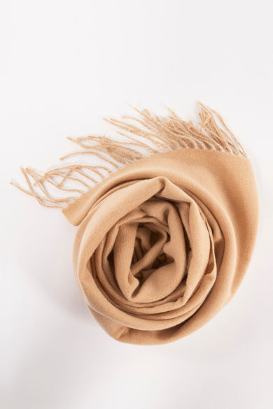 Chapeau d'hiver rose Access® avec franges, enroulé comme une rose sur un fond blanc.