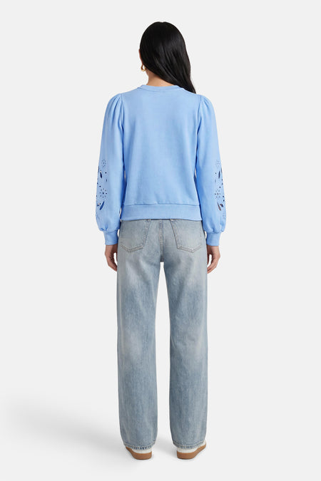 Blauwe sweater van HAILYS, met lange mouwen met decoratieve perforaties, gecombineerd met een jeans.