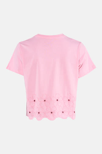 Roze T-shirt met korte mouwen van HAILYS, met bloemendetail aan de onderkant, op een witte achtergrond.
