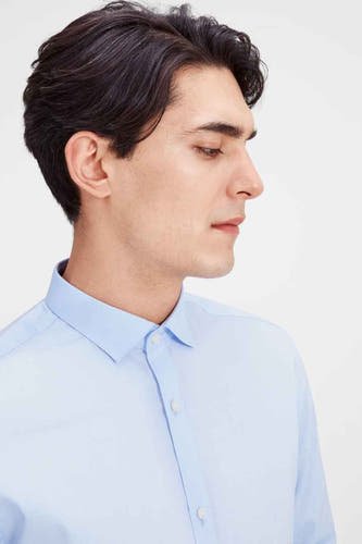 Blauw overhemd met lange mouwen van PREMIUM by JACK & JONES, close-up zijprofiel van de mannelijke model.
