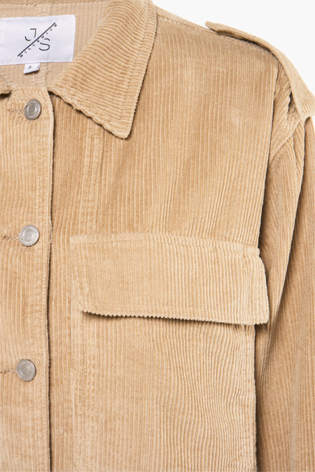 Manteau de corduroy beige MILLENIUM, avec une poche visible et des boutons argentés.