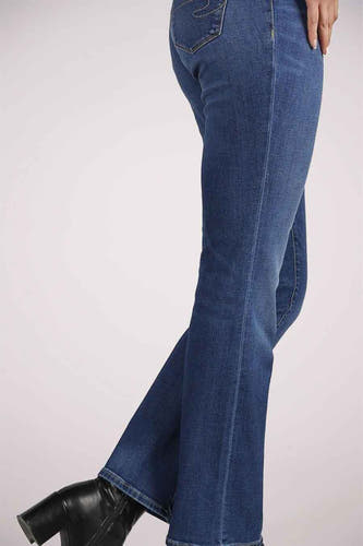 Middenblauwe denim bootcut jeans van Lee Cooper, gecombineerd met zwarte leren laarzen met hak.