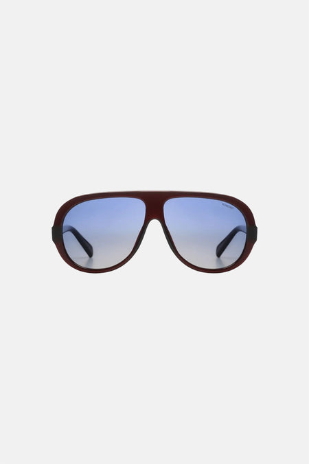 Lunettes rouge-brun de KOMONO avec verres à dégradé bleu et logo.