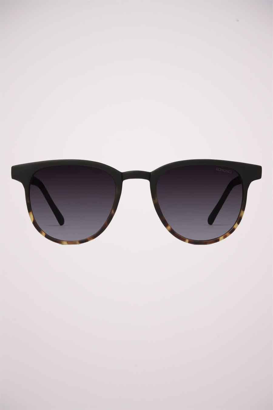 Lunettes de soleil noires KOMONO avec un motif tortue sur la moitié inférieure du cadre.