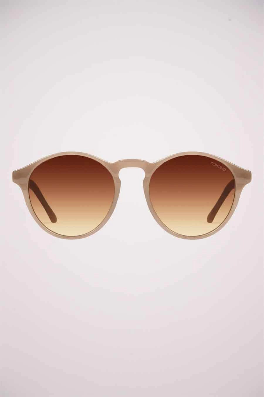 Beige zonnebril van KOMONO, met bruin verloopglas en afgeronde monturen.
