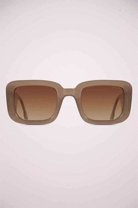 Beige zonnebril van KOMONO, met vierkante glazen en een bruin kleurverloop.