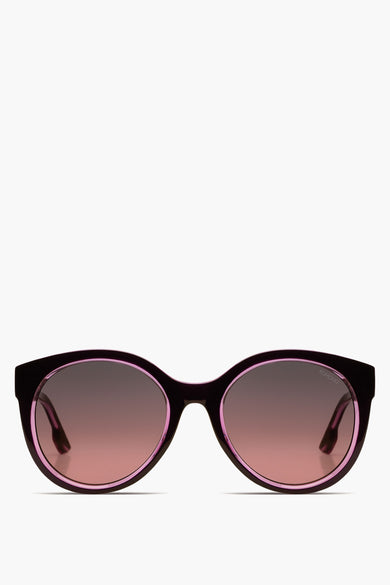 Lunettes vertes de KOMONO, avec des détails roses autour des verres et une teinte brune dans les verres.