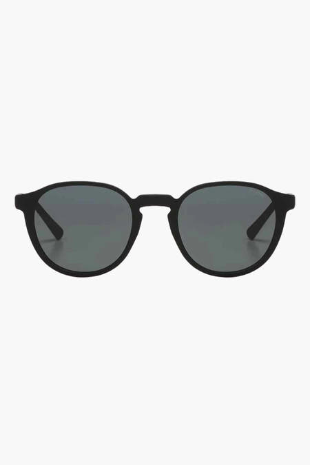 Lunettes de soleil noires KOMOMONO, avec un cadre rond et des verres foncés.