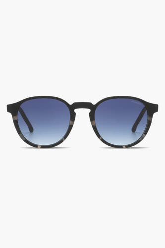 Zwarte zonnebril van KOMONO met blauw verlopende glazen en een gemêleerd montuur.
