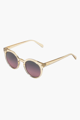 Lunettes de soleil beige de KOMONO, avec des verres ronds dégradés, posées sur un fond blanc.
