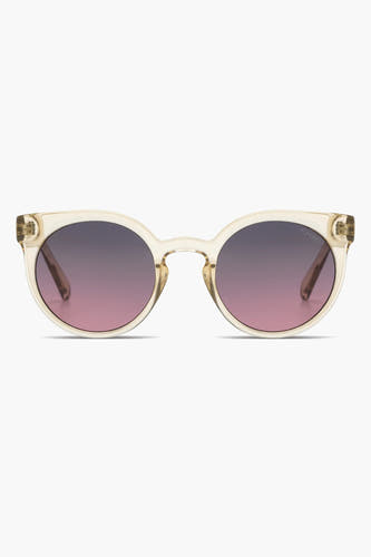 Lunettes de soleil beige de Komono avec des verres teintés violet-rose et un cadre transparent.