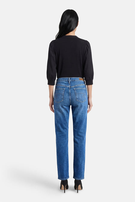 Middenblauwe denim rechte jeans van Lee Cooper, achterkant gezien, gecombineerd met een zwarte top en zwarte hakken.