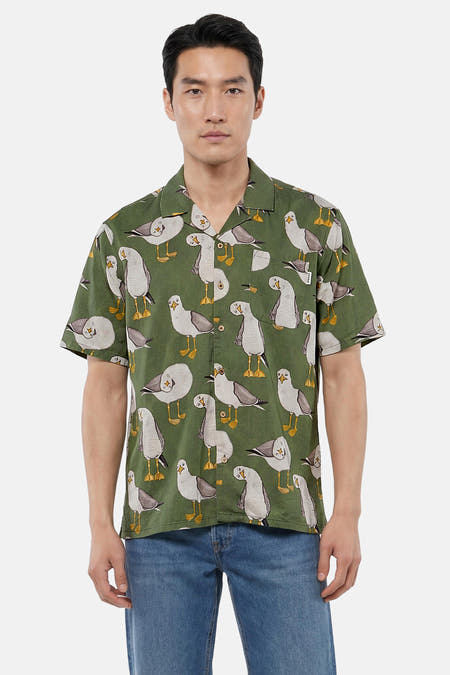 Groen overhemd met korte mouwen van LAKOR, met meeuwenprint, gedragen door een man in jeans.