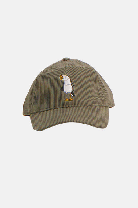 Groene pet van LAKOR met corduroy textuur en een geborduurde afbeelding van een vogel.
