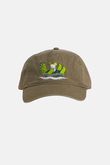 Groene pet van LAKOR, met geborduurde afbeelding van een krokodil in een bootje met cocktail.