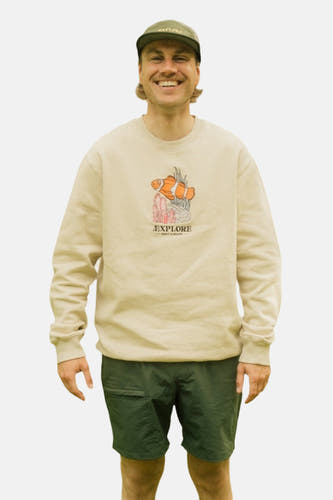Ecru sweater van LAKOR, met een grafische print van een clownvis en groene shorts.

