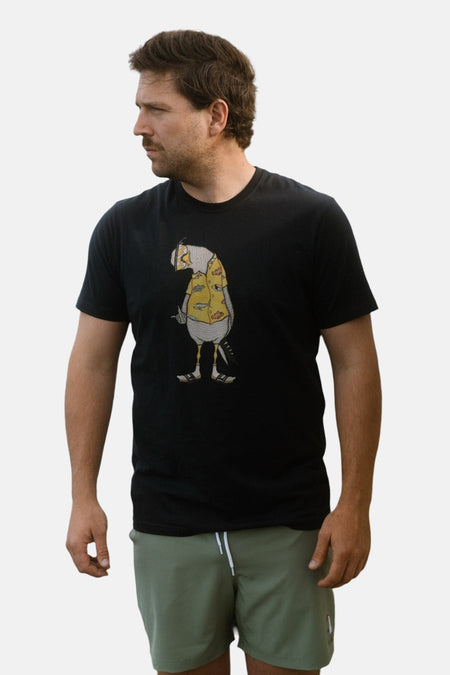 Zwart T-shirt van LAKOR met korte mouwen, met een illustratie van een figuur in een geel shirt.
