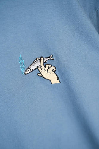 Blauw T-shirt met korte mouwen van LAKOR, met geborduurde hand die een rokende vis vasthoudt.