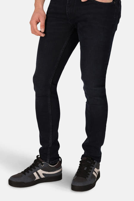 Jean slim fit en denim bleu noir de Lee Cooper, avec une coupe élégante et des chaussures.