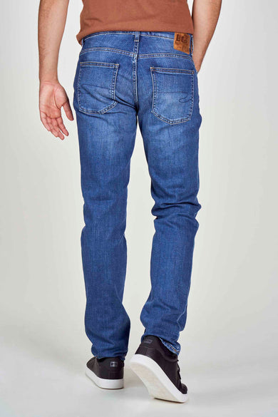 Jean bleu droit de Lee Cooper, vu de derrière, avec des chaussures sombres et une chemise brune.