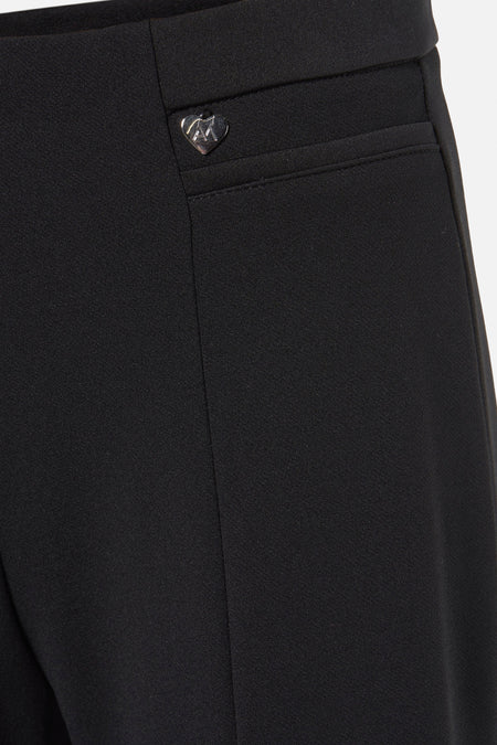 Zwarte broek van AMELIE ET AMELIE met hartvormig logo op de taille, gladde stof, close-up vooraanzicht