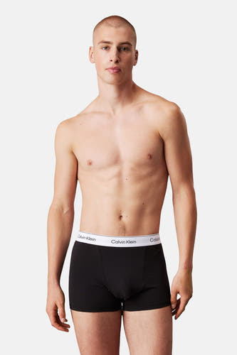 Sous-vêtement noir de Calvin Klein porté par un homme sans chemise sur un fond blanc.