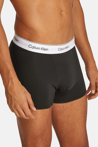 Sous-vêtement noir de Calvin Klein porté par un homme avec les mains derrière le dos.