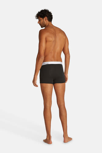 Sous-vêtement noir de Calvin Klein, vue arrière d'un homme aux cheveux bouclés et à la peau brune.